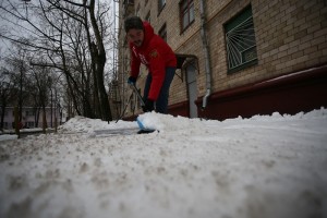 Муниципальный депутат Илья Свиридов убирает снег во дворе дома.